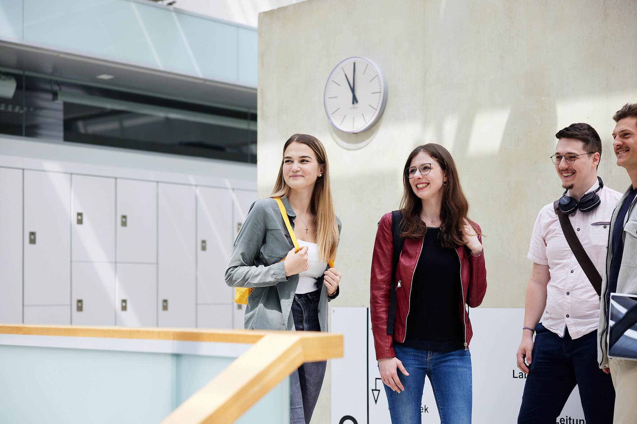 Vier Studenten stehen gemeinsam zwischen einer Treppe und einigen Spinden in der FH Wels.