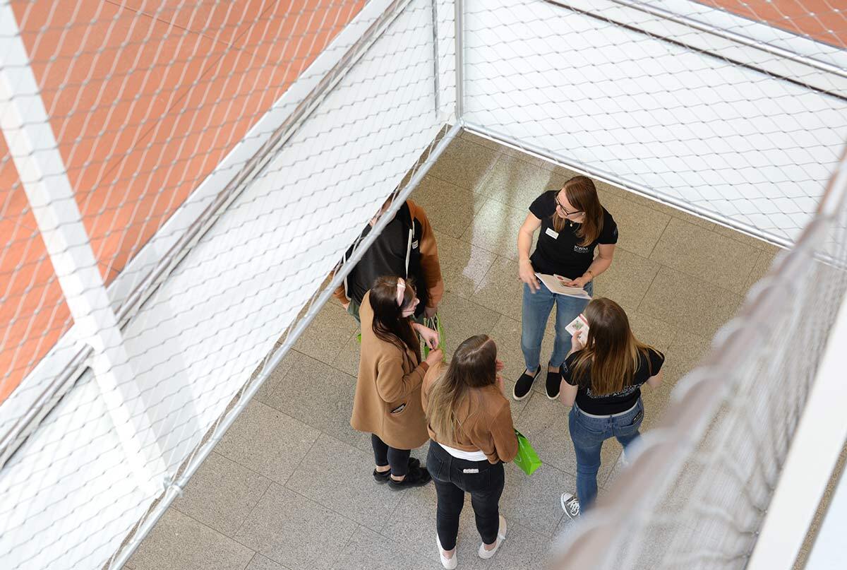 Eine Gruppe von Studenten stehen in der Aula