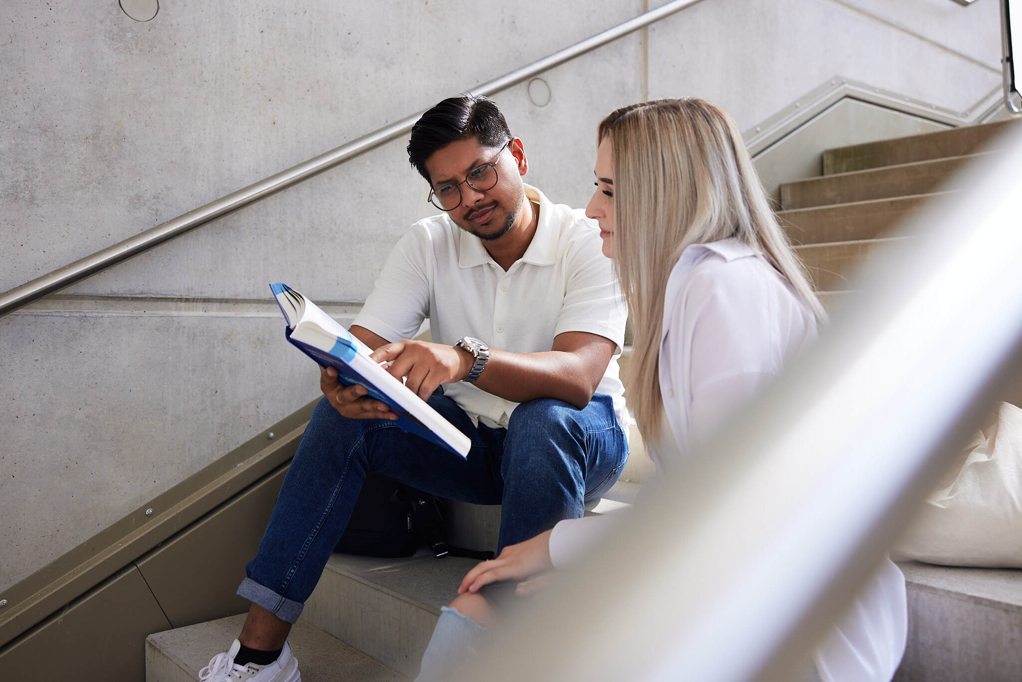 zwei Studenten unterhalten sich auf einer Treppe der FH Steyr